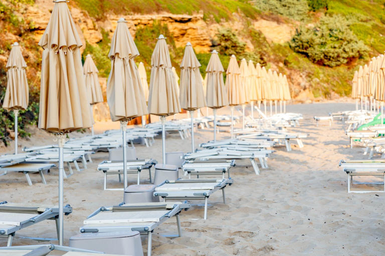 An empty beach with sunbeds and umbrellas at a dawn