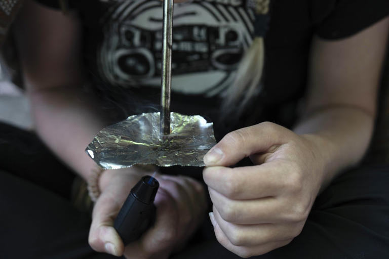 FILE - A homeless woman person smokes fentanyl, June 28, 2024, in Portland, Ore. (AP Photo/Jenny Kane, File)