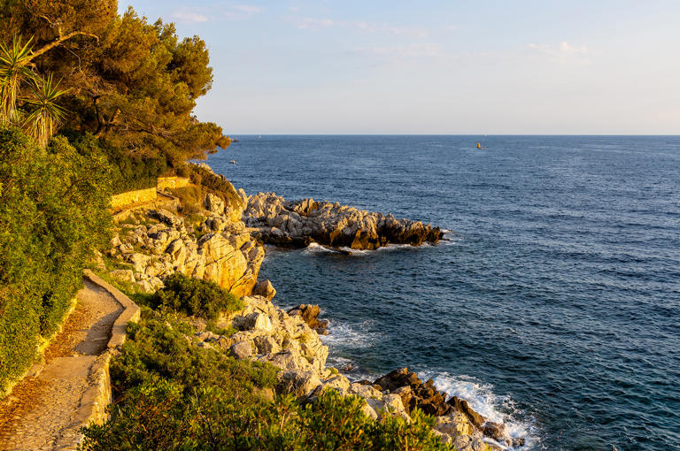 Rocky shoreline of Saint-Jean-Cap-Ferrat resort town with sightseeing path on Cap Ferrat cape at French Riviera in France