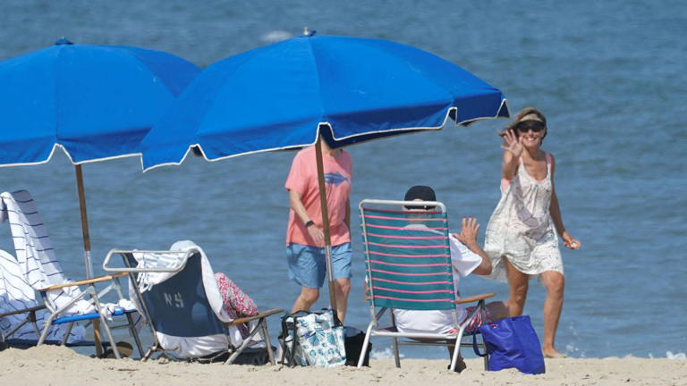 President Joe Biden waves back to a well-wisher while sitting on the beach in Rehoboth, Delaware, on August 28. - Kevin Lamarque/Reuters