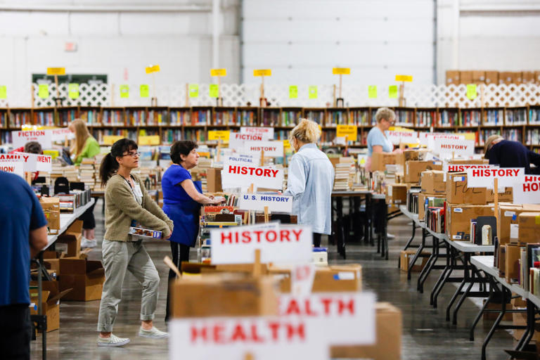 Friends of the Library volunteers unpack and sort boxes of books for the Spring 2023 Book Sale at the Ozark Empire Fairgrounds E-Plex on Monday, April 24, 2023.