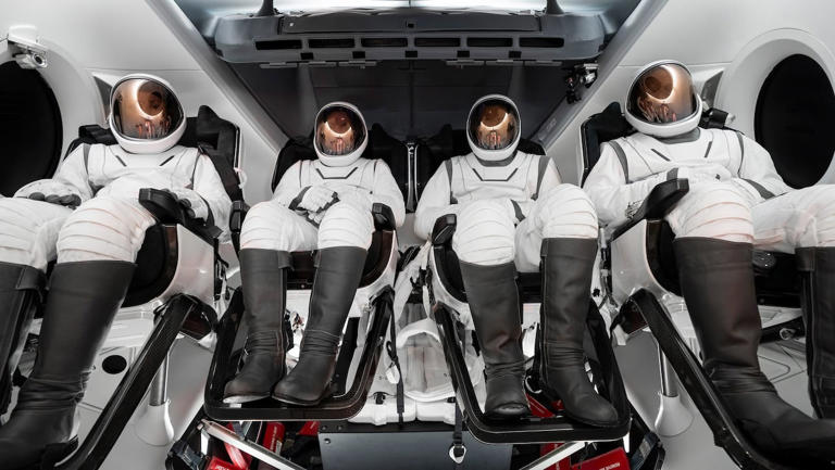 The four Polaris Dawn crew members sit inside SpaceX's Crew Dragon spacecraft wearing the newly designed extravehicular spacesuits. (SpaceX)