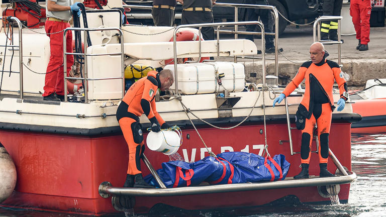 Italian firefighter divers bring ashore in a plastic bag the body of one of the victims of a shipwreck, in Porticello, Sicily, southern Italy, Thursday, Aug. 22, 2024. Divers searching the wreck of the superyacht Bayesian that sank off Sicily on Monday recovered a fifth body on Thursday and continued to search for one more as investigators sought to learn why the vessel sank so quickly. (AP Photo/Salvatore Cavalli)