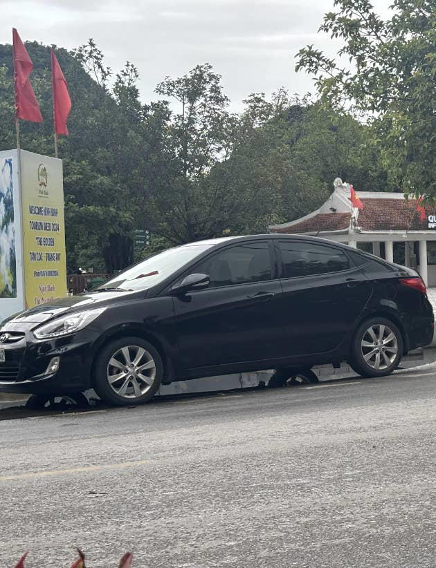 It is the reflection from a puddle under the car. u/CornwallBingo further explains, "The car is parked over a shallow puddle that ends just before the tires closest to us. You can see a low curb and its reflection to the right of the rear tires, below the rear bumper." u/catatlaw / reddit.com