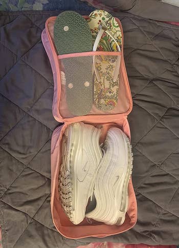 reviewer image showing the show bag open with a pair of sneakers and two pairs of flip flops in it