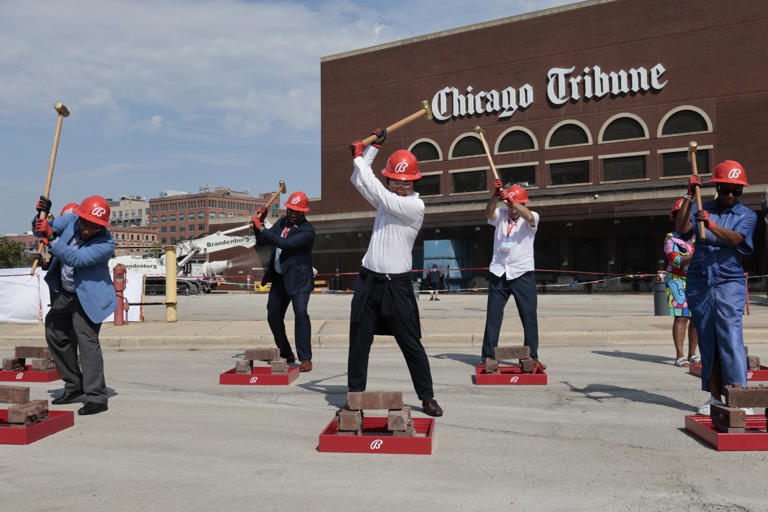 Bally’ s Chairman Soo Kim, center, swings a sledgehammer with others outside the former Chicago Tribune Freedom Center at a demolition event on Aug. 27, 2024, in Chicago.