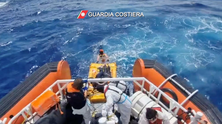 Italian coast guard members rescue seven survivors of a capsized boat that had set off from Libya a few days ago [Guardia Costiera/Reuters]