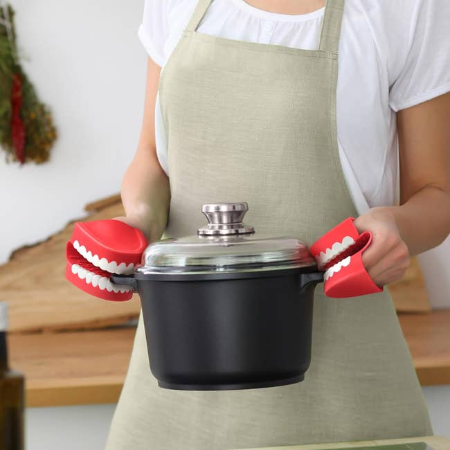 person holds pot with clattering teeth toy-shaped grips