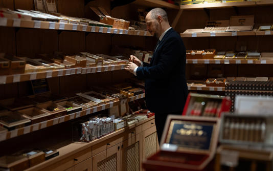 One of JJ Fox’s cigar sommeliers browses their supplies - Christopher Pledger for the Telegraph