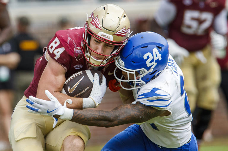 Florida State tight end Kyle Morlock (84) is tackled by Memphis defensive back Greg Rubin (24) during the second half of an NCAA college football game, Saturday, Sept. 14, 2024, in Tallahassee, Fla. Memphis defeated Florida State 20-12. (AP Photo/Colin Hackley)