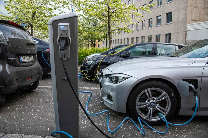 Carros elétricos sendo carregados numa rua de Oslo Foto: Jonathan Nackstrand/AFP