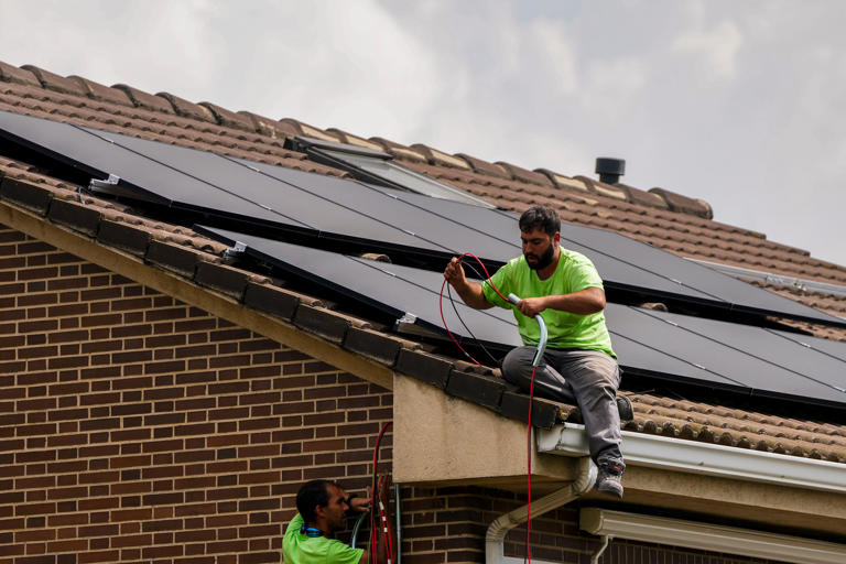 Workers install solar pannels on the roof of a house in Rivas Vaciamadrid, Spain, on 15 September 2022. (AP)