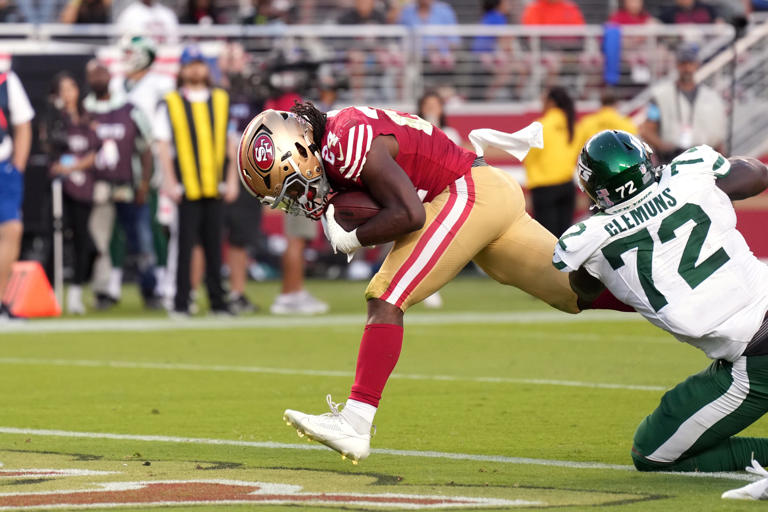 Sep 9, 2024; Santa Clara, California, USA; San Francisco 49ers running back Jordan Mason (center) scores a touchdown against New York Jets defensive end Micheal Clemons (72) during the third quarter at Levi's Stadium. Mandatory Credit: Darren Yamashita-Imagn Images