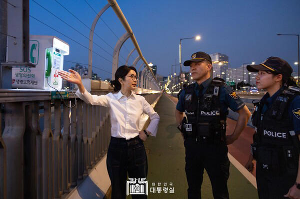 김건희 씨가 10일 '세계 자살 예방의 날'을 맞아 서울 마포대교에서 마포경찰서 용강지구대 근무자와 함께 '생명의 전화'를 살펴보며 대화하고 있다.(사진=대통령실 홈페이지 갈무리)