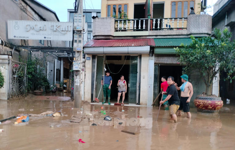 Tiền Phong Tranh thủ khi nước chưa rút hẳn để đẩy bùn đất ra khỏi nhà, tránh tình trạng ùn ứ. 1