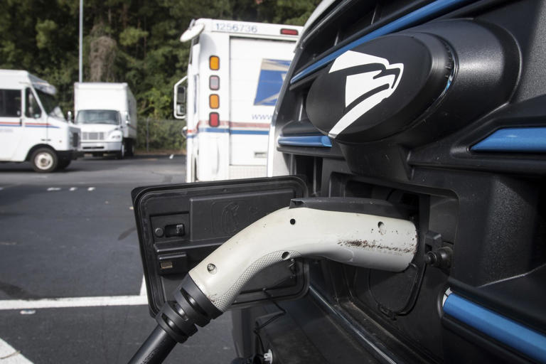 New mail delivery vehicles are charging at a station at a post office on Thursday, Sept. 5, 2024, in Athens Ga. (AP Photo/Ron Harris)