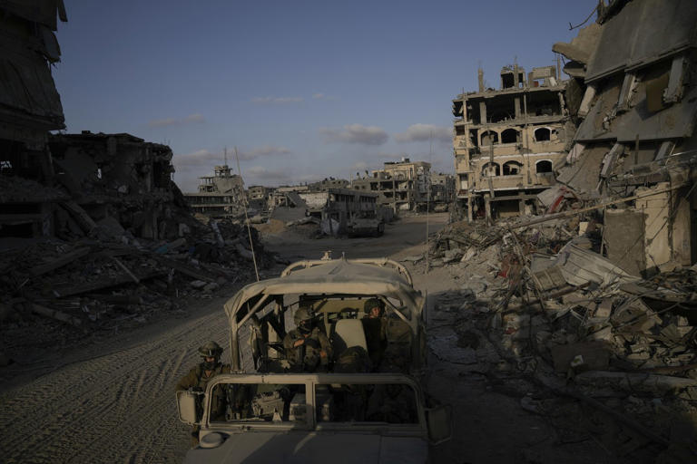 Israeli soldiers move next to destroyed buildings following Israeli strikes during a ground operation in the Gaza Strip on Friday, Sept. 13, 2024. (AP Photo/Leo Correa)