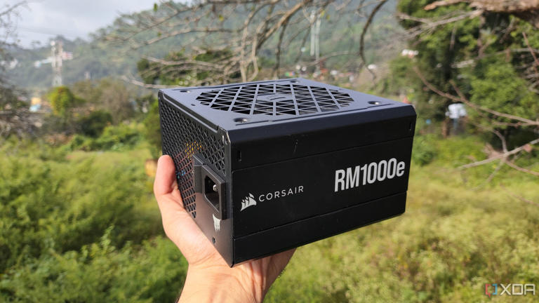 A person holding a Corsair RM1000e PSU