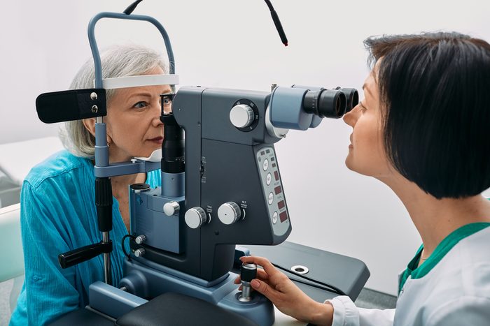 Female Optometrist Doing Sight Test To Senior Woman At Modern Ophthalmology Clinic. Eye Exam And Vision Diagnostic
