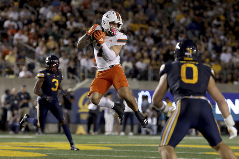 Miami wide receiver Xavier Restrepo (7) catches a pass against California linebacker Cade Uluave (0) during the first half of an NCAA college football game in Berkeley, Calif., Saturday, Oct. 5, 2024. (AP Photo/Jed Jacobsohn)