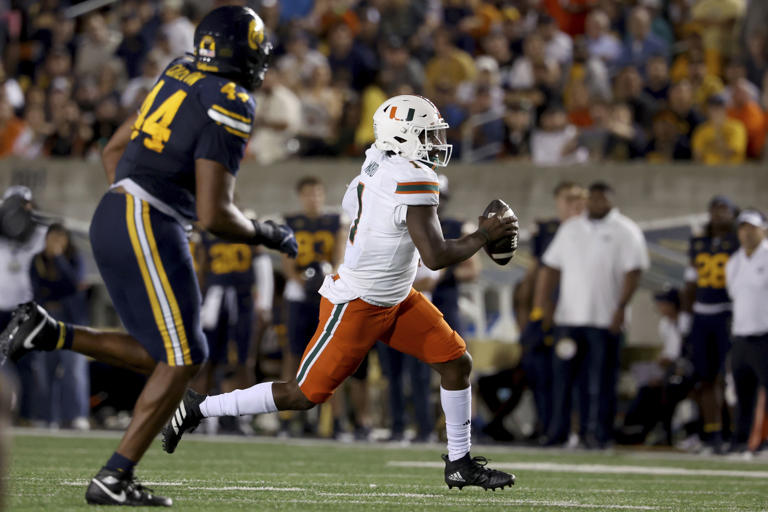 Miami quarterback Cam Ward (1) runs for a touchdown against California linebacker Xavier Carlton (44) during the second half of an NCAA college football game in Berkeley, Calif., Saturday, Oct. 5, 2024. (AP Photo/Jed Jacobsohn)