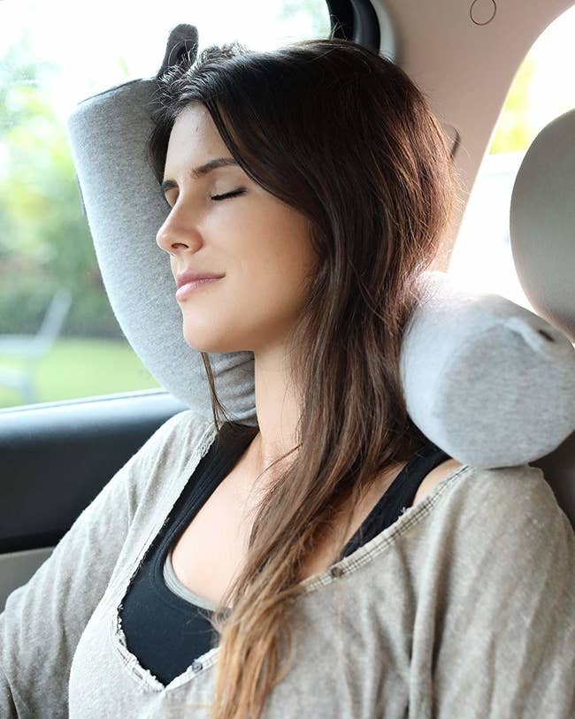 model sleeps on bendy pillow pushed against window