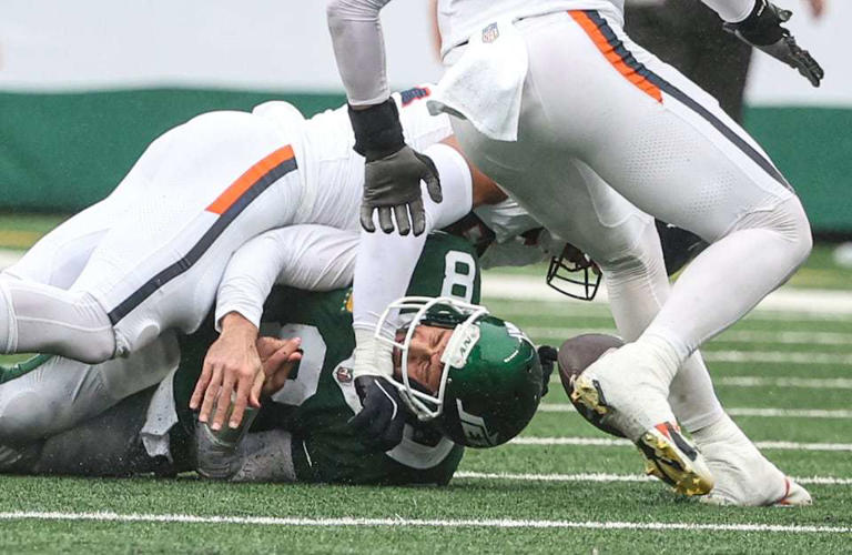 New York Jets quarterback Aaron Rodgers (8) grimaces as he loses the ball while being sacked by Denver Broncos linebacker Jonah Elliss (52) during the fourth quarter, Sunday, Sept. 29 2024, in East Rutherford, N.J. The Broncos won, 10-9.