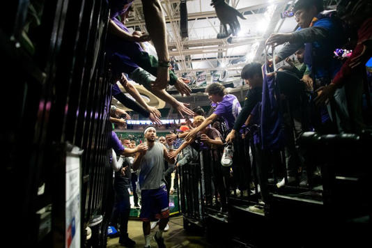 Phoenix guard Devin Booker (1) high-fives fans on his way out of the arena after a NBA preseason game between the Phoenix Suns and Detroit Pistons at the Breslin Center in East Lansing, Michigan, on Tuesday, Oct. 8, 2024.