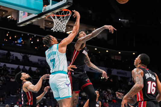 Oct 8, 2024; Charlotte, North Carolina, USA; Miami Heat center Kel'el Ware (7) blocks a shot by Charlotte Hornets forward Keyontae Johnson (7) during the second half at Spectrum Center. Mandatory Credit: Jim Dedmon-Imagn Images