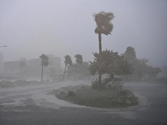 A car is seen parked as it rains heavily in Fort Myers, Fla., Oct. 9, 2024, as Hurricane Milton approaches.