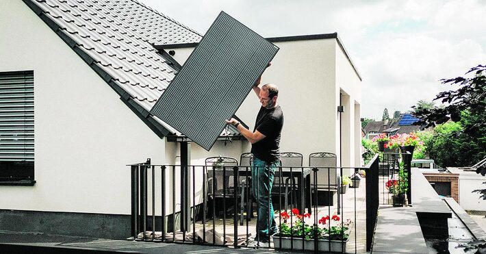 Morador instala um painel solar portátil no telhado de sua casa na Alemanha Foto: Patrick Junker/NYT