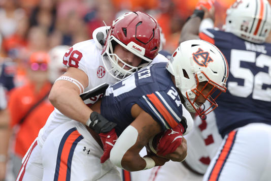 Sep 28, 2024; Auburn, Alabama, USA; Oklahoma Sooners linebacker Danny Stutsman (28) tackles Auburn Tigers running back Jarquez Hunter (27) during the first quarter at Jordan-Hare Stadium. Mandatory Credit: John Reed-Imagn Images