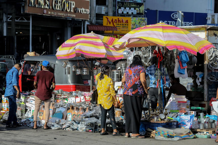 People buy goods at a roadside shop on a busy street in Colombo. Sri Lanka's new leader Anura Kumara Dissanayake is expected to pursue policies that will benefit the poor. Photo: EPA-EFE