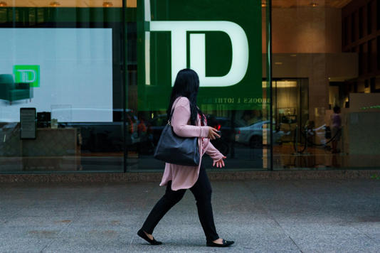 Shares of Toronto-Dominion Bank were down in early trading following reports the bank is nearing a settlement regarding failures of its anti-money laundering safeguards in the United States. A person walks past a TD Bank sign in the financial district in Toronto on Tuesday, Sept. 20, 2022. THE CANADIAN PRESS/Alex Lupul