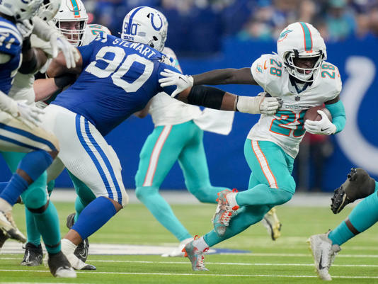 Miami Dolphins running back De'Von Achane (28) rushes past Indianapolis Colts defensive tackle Grover Stewart (90) on Sunday, Oct. 20, 2024, during a game against the Miami Dolphins at Lucas Oil Stadium in Indianapolis.