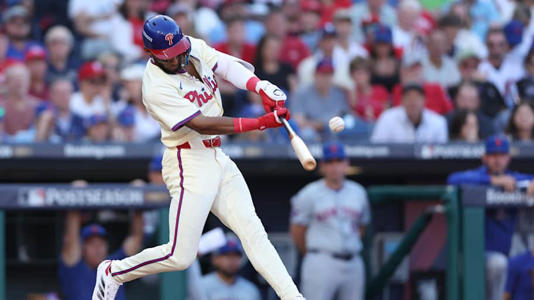 Oct 6, 2024; Philadelphia, Pennsylvania, USA; Philadelphia Phillies outfielder Johan Rojas (18) hits a single in the third inning against the New York Mets during game two of the NLDS for the 2024 MLB Playoffs at Citizens Bank Park. | Bill Streicher-Imagn Images