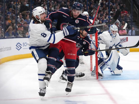 Justin Danforth (17) of the Columbus Blue Jackets hits Chris Tanev (8) of the Toronto Maple Leafs during the second period at Nationwide Arena on Tuesday, Oct. 22, 2024, in Columbus, Ohio. 