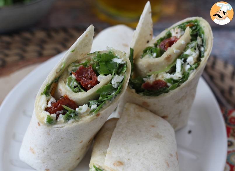 Mediterraner wrap, gefüllt mit hummus, rucola, paprika und feta
