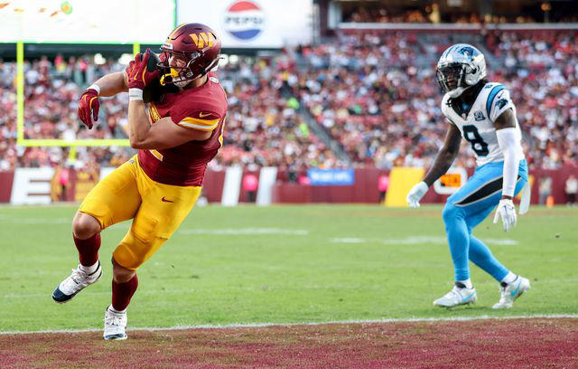 Patrick Smith/Getty Ben Sinnott #82 of the Washington Commanders scores a touchdown against the Carolina Panthers during the third quarter at Northwest Stadium on October 20, 2024