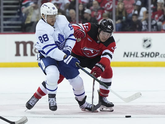 William Nylander #88 of the Toronto Maple Leafs battles with Curtis Lazar of the New Jersey Devils.