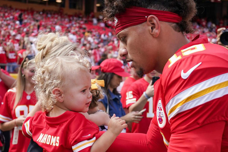 Kansas City Chiefs quarterback Patrick Mahomes (15) picks up son Bronze. Denny Medley-Imagn Images