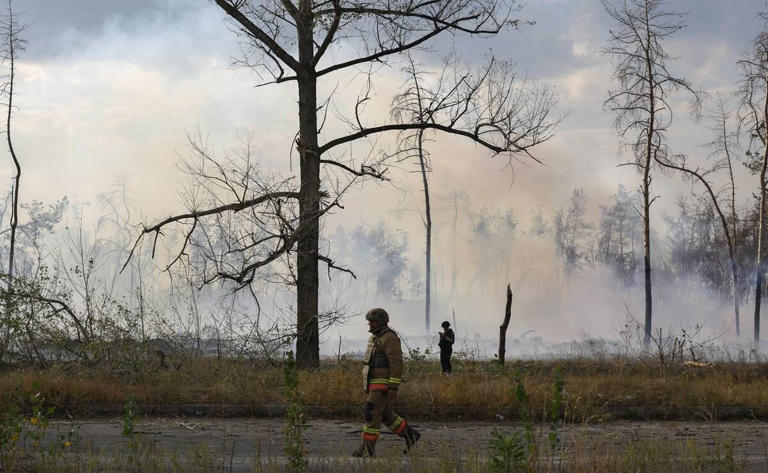 Rescatistas ucranianos trabajan mientras se eleva humo en el lugar de un bombardeo con bomba planeadora en Járkov, Ucrania. Foto: EFE