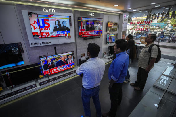 Indian people watch results of U.S. elections on a television in Guwahati, India, Wednesday, Nov. 6, 2024. (AP Photo/Anupam Nath)