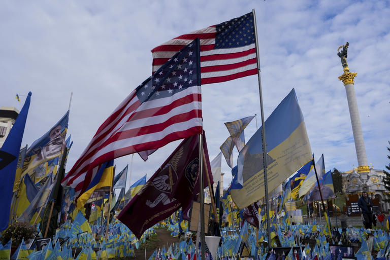 Las banderas de Estados Unidos y Ucrania en honor de los soldados caídos ondean frente a una estatua en la plaza central, en Kiev, Ucrania, el martes 5 de noviembre de 2024. (AP Foto/Alex Babenko)