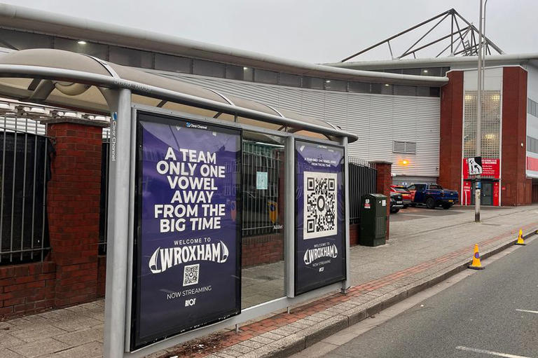 An advert for 'Welcome to Wroxham' outside Wrexham's AFC's Racecourse Ground