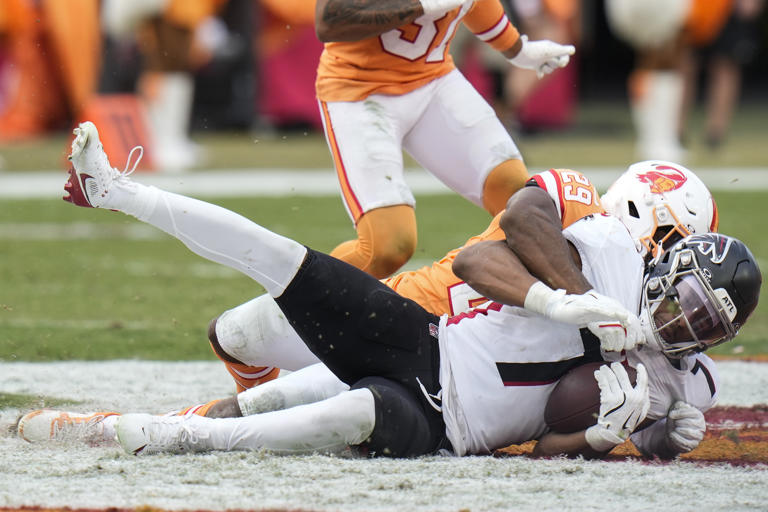 Tampa Bay Buccaneers cornerback Tyrek Funderburk (24) hits Atlanta Falcons running back Bijan Robinson (7) during the second half of an NFL football game, Sunday, Oct. 27, 2024, in Tampa. (AP Photo/Chris O'Meara)