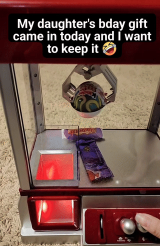 A claw machine holds a toy ball, captioned