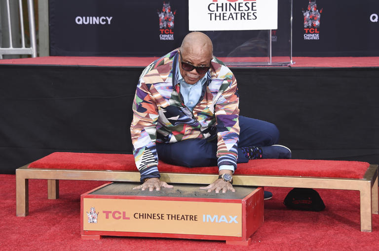 Quincy Jones poses for photos after placing his hands in wet cement during a hand and footprint ceremony honoring Jones at the TCL Chinese Theatre on Tuesday, Nov. 27, 2018, in Los Angeles.