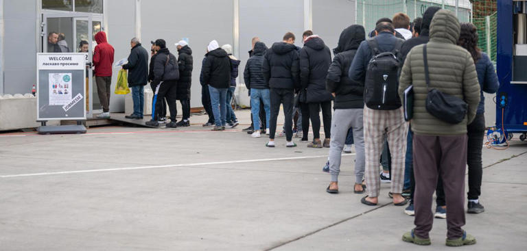 Am ehemaligen Berliner Flughafen Tegel stehen Migranten für eine Jobmesse an Christophe Gateau/dpa
