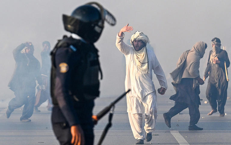 A Pakistan Tehreek-e-Insaf (PTI) supporter gestures after tear gas was allegedly fired by the police to disperse the crowd during protests over the weekend - AAMIR QURESHI/AFP